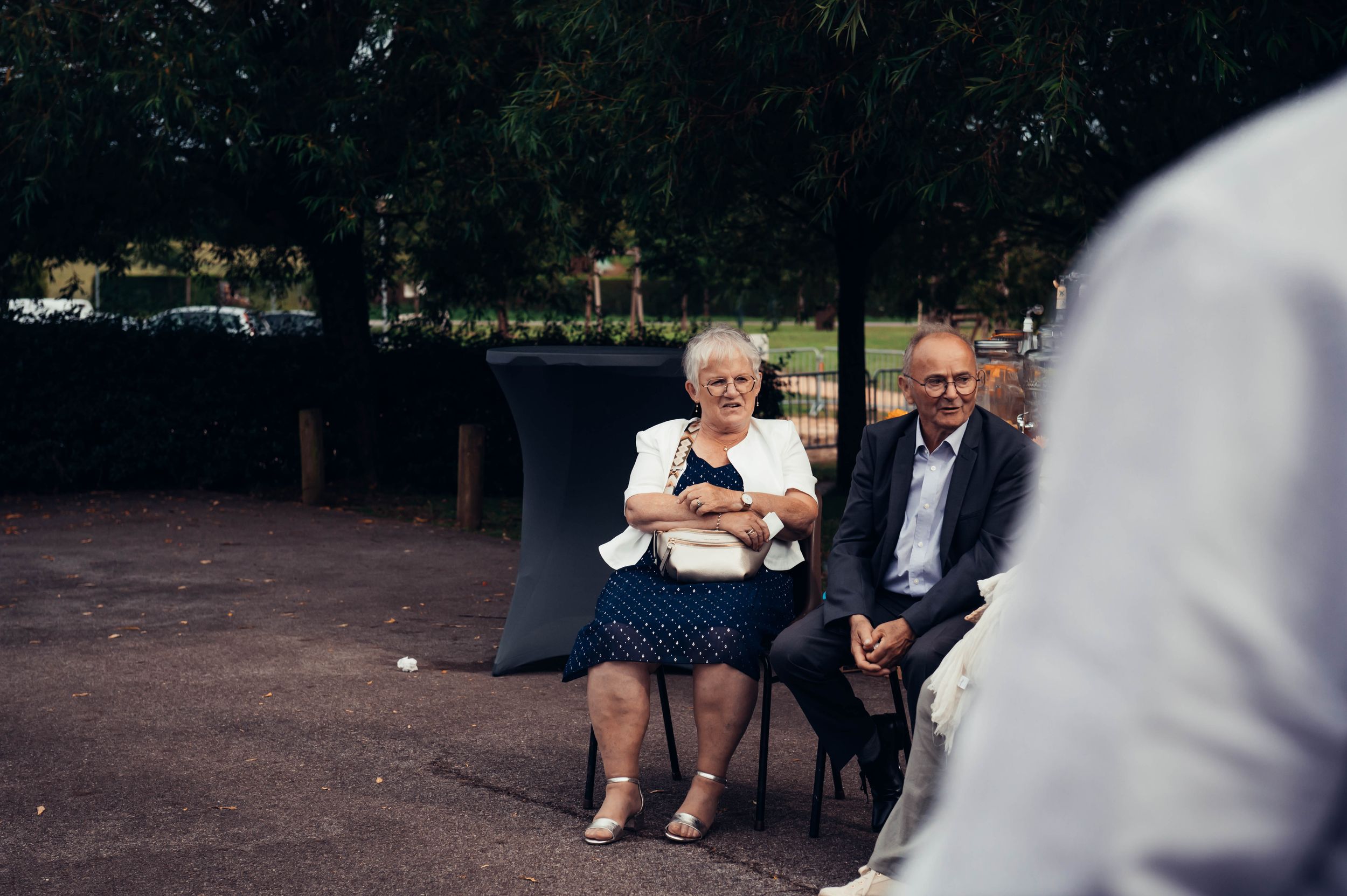 Invités assis et échangeant lors du cocktail de mariage en extérieur, ambiance conviviale en Bretagne.