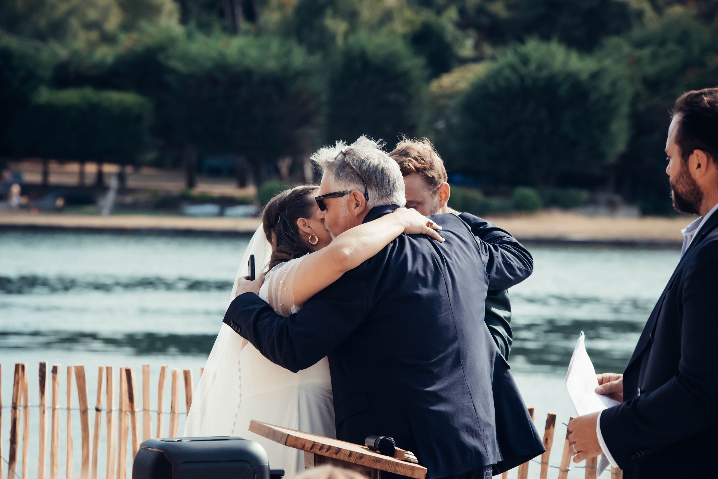 Étreinte émouvante entre invités lors d’un mariage en bord de mer en Bretagne.