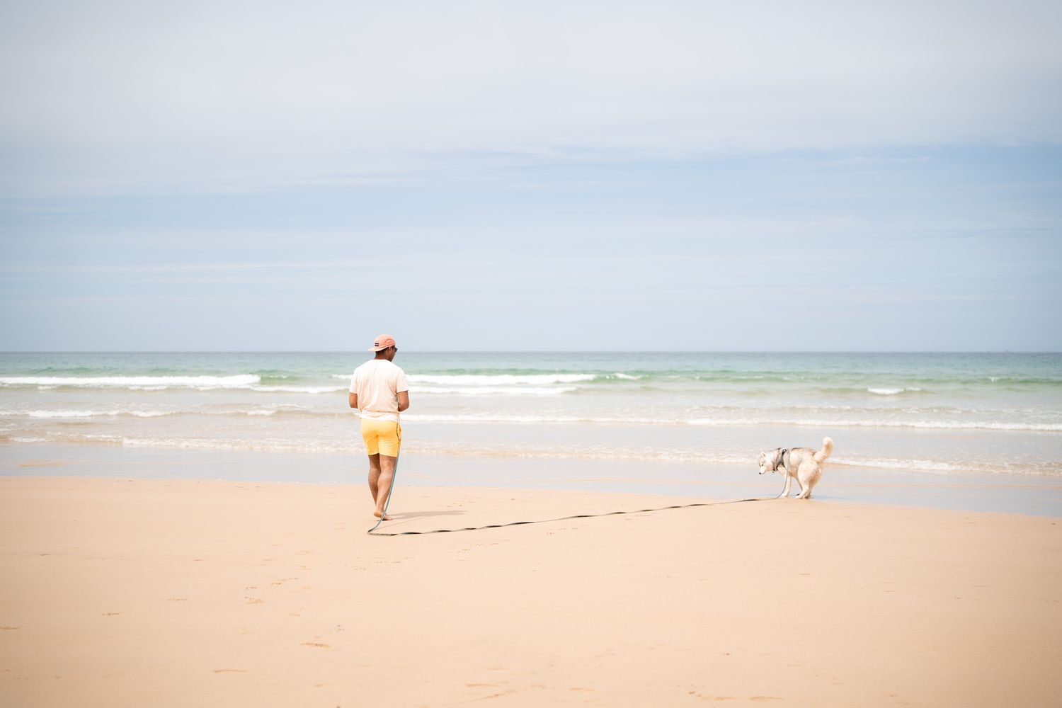 promeneur avec son chien sur watergate beach dans les cornouailles en angleterre