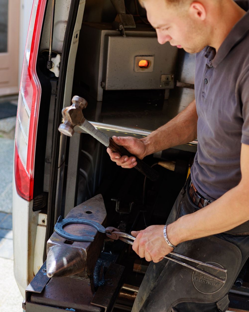 A person in gray clothing working on what appears to be a repair or maintenance task in a vehicle interior.