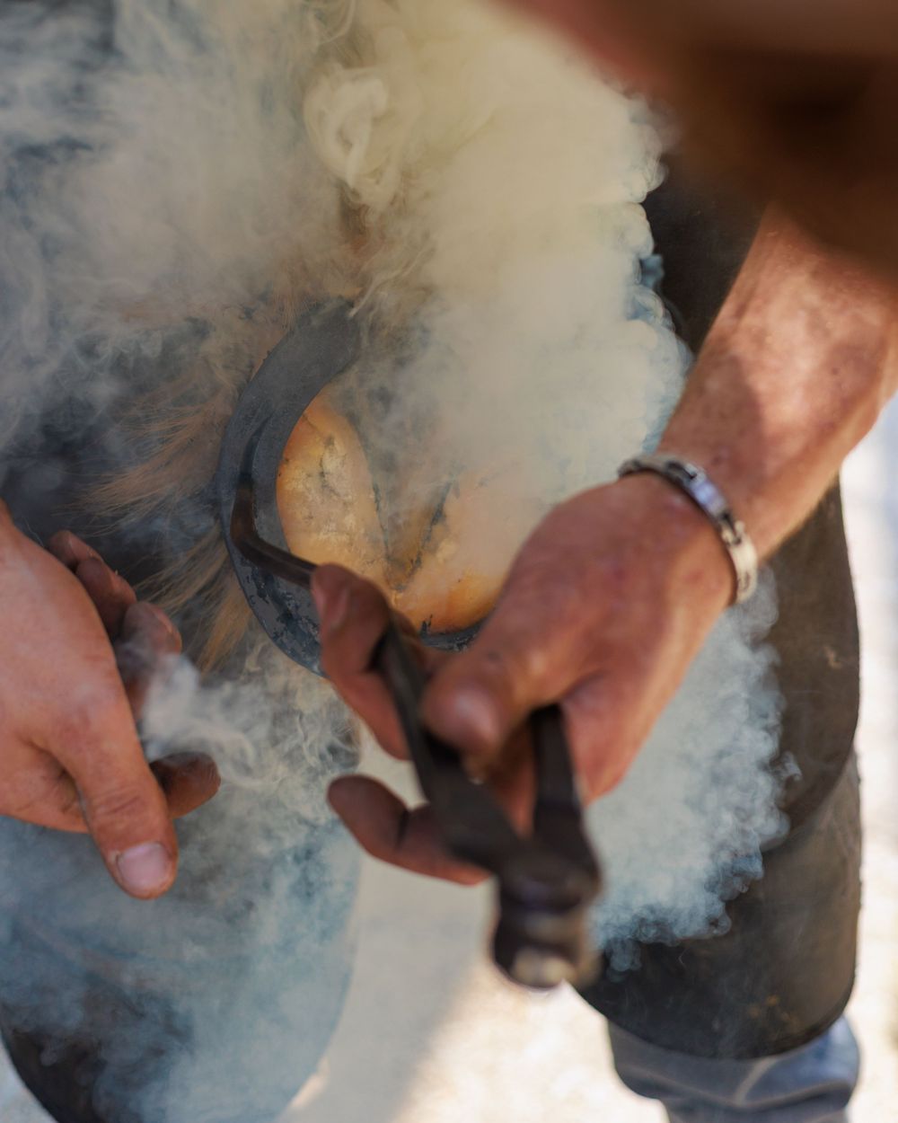 Series of hands working with smoke or vapor in a detailed process.