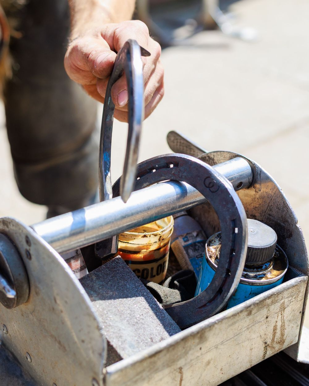 Close-up view of a plumbing repair showing someone fixing a toilet tank mechanism with tools.
