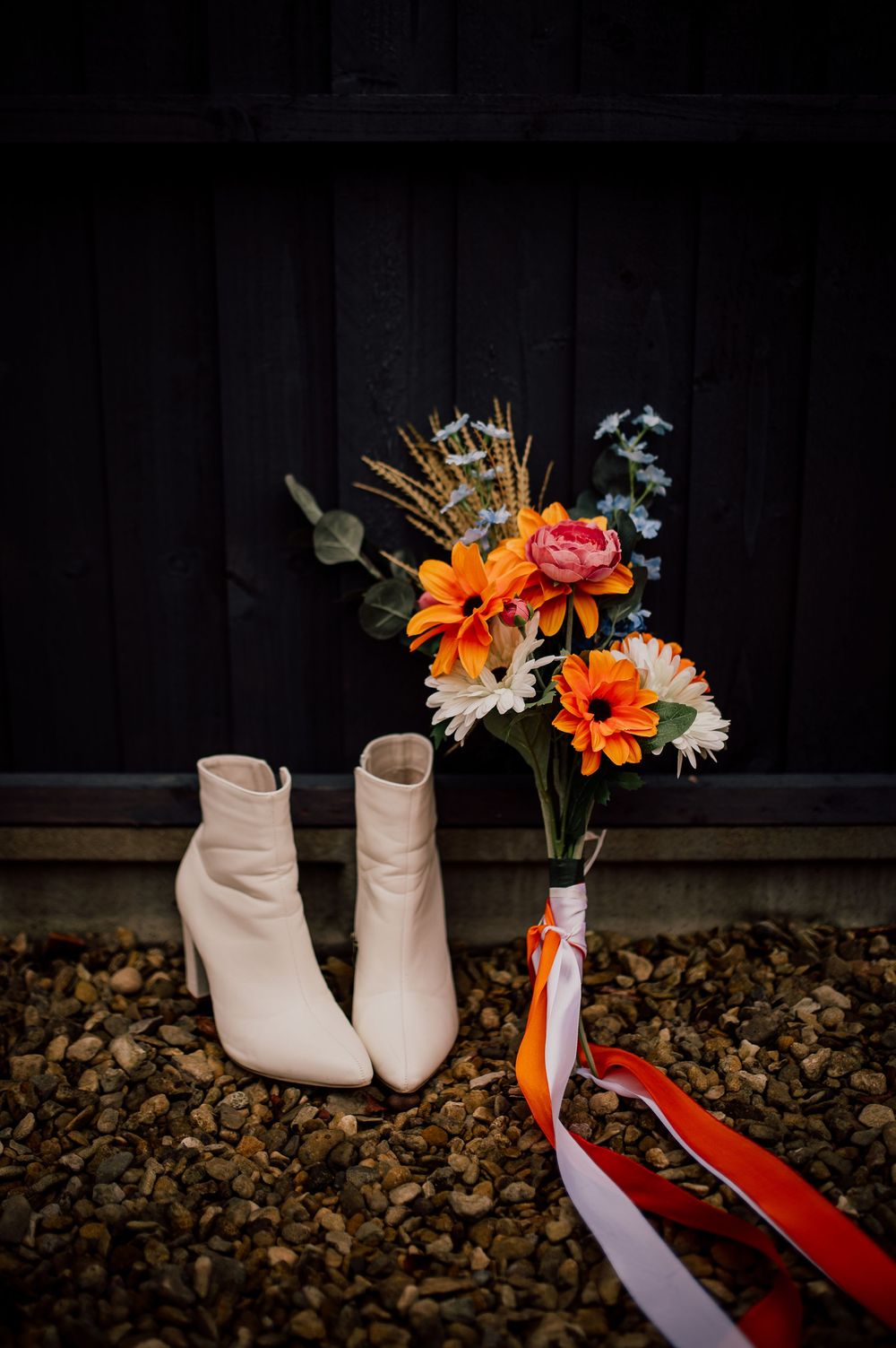 A sequence of artistic shots showing beige ankle boots with orange and pink flowers against a dark background.