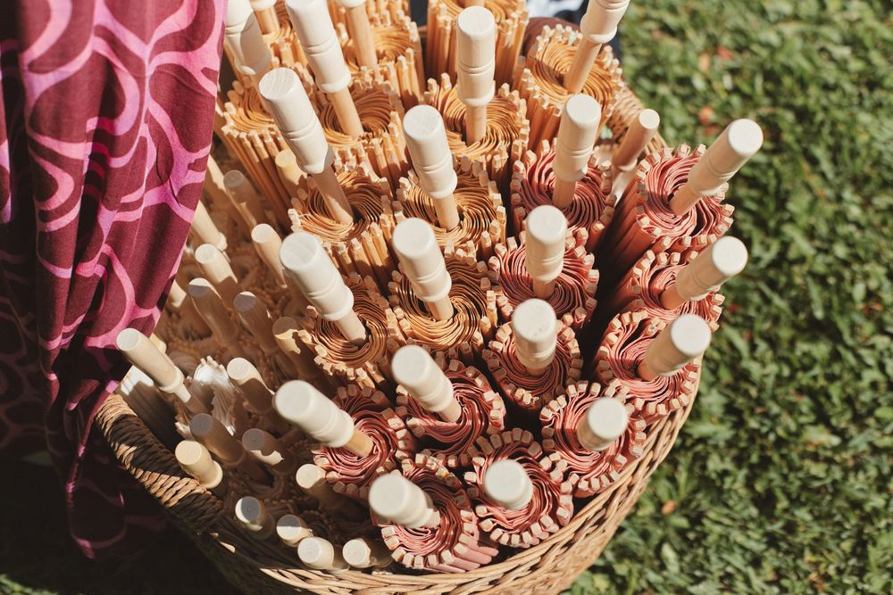 Basket filled with wooden sticks and pearl decorations arranged on grass.