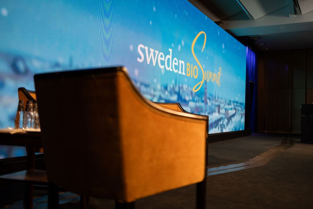 A dark interior room with blue lighting and illuminated signage displaying 'Sweden' on the wall.