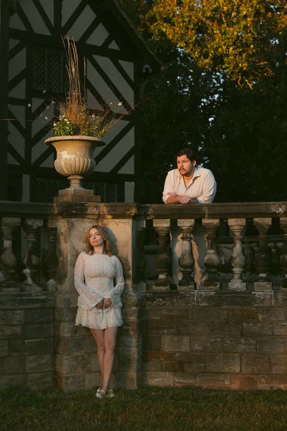 A romantic outdoor portrait at sunset with a stone balustrade against Tudor-style architecture at Agecroft Hall in Richmond, Virginia