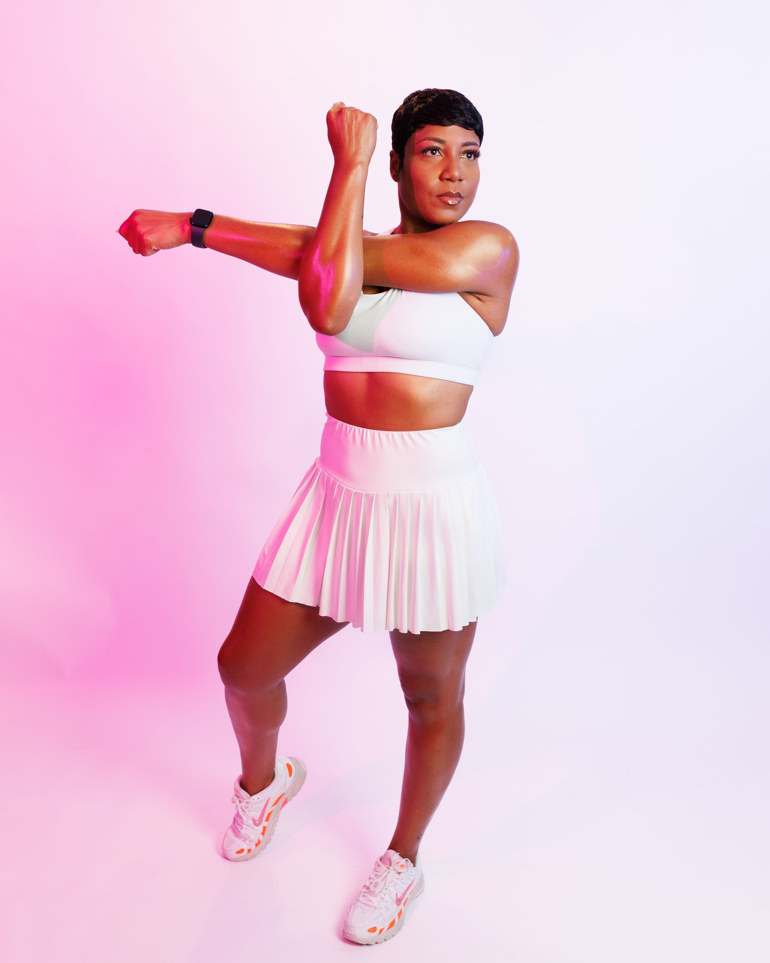 A figure in a white tennis dress performs a dynamic series of athletic poses against a pink gradient background.