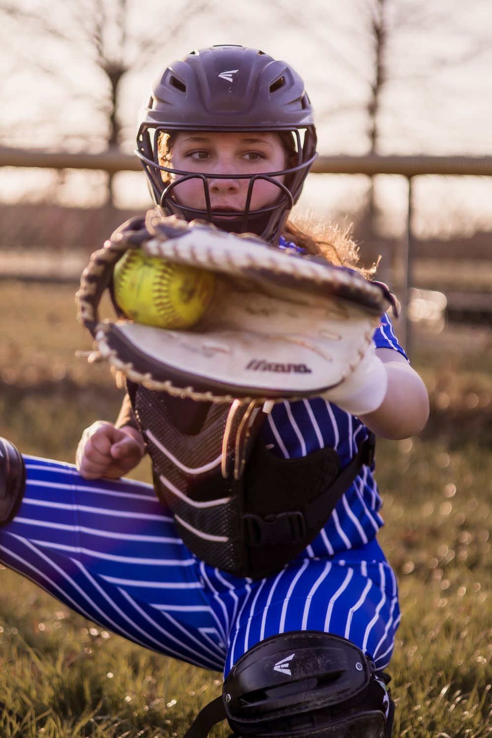 Close-up sequence showing a softball player's glove and catching motion against a sunset background.