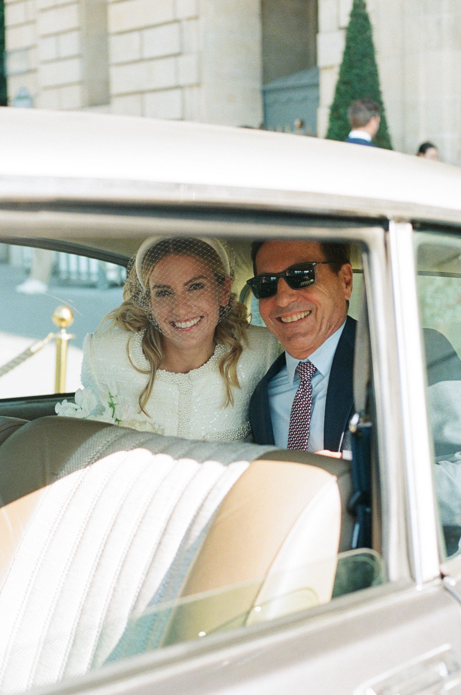 A series of four connected photos showing a couple in a vintage white car on their wedding day.