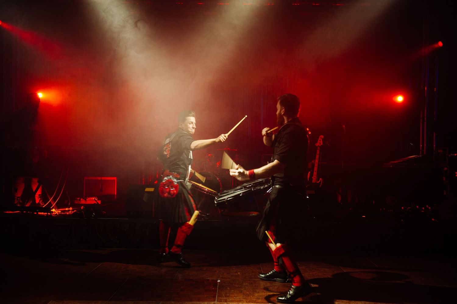 Burns Night performance with dramatic red stage lighting and silhouetted performers.