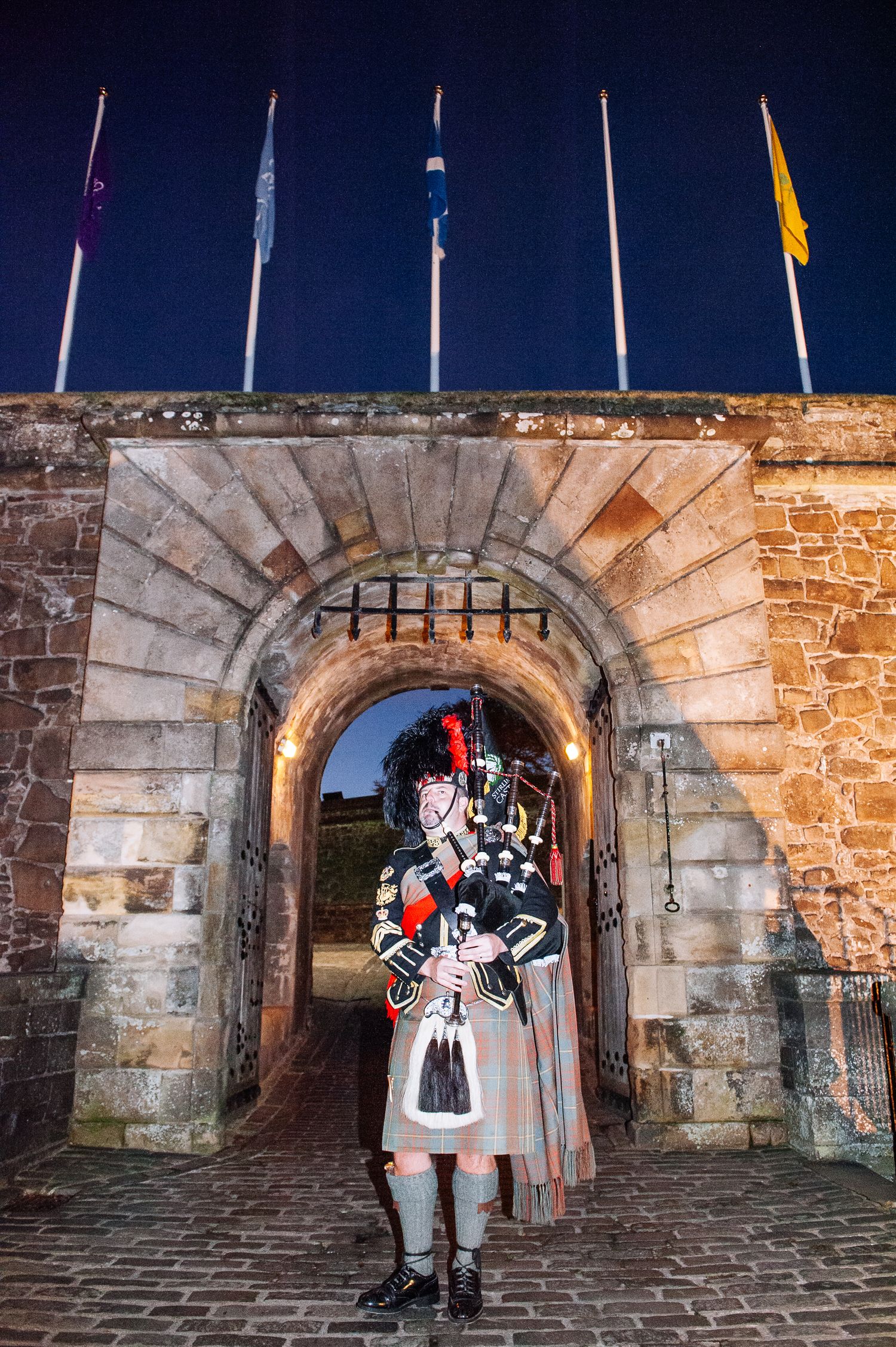 Traditional Scottish bagpiper welcoming guests to a corporate event at Stirling Castle