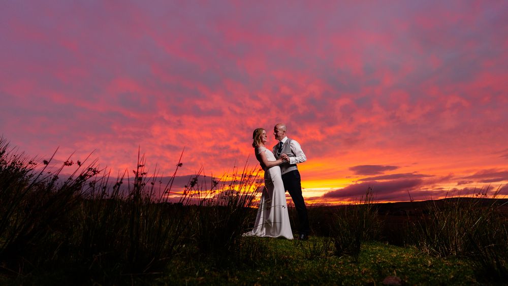 Panoramic view of figures in silhouette against a fiery red sunset sky. Woodhill Hall.