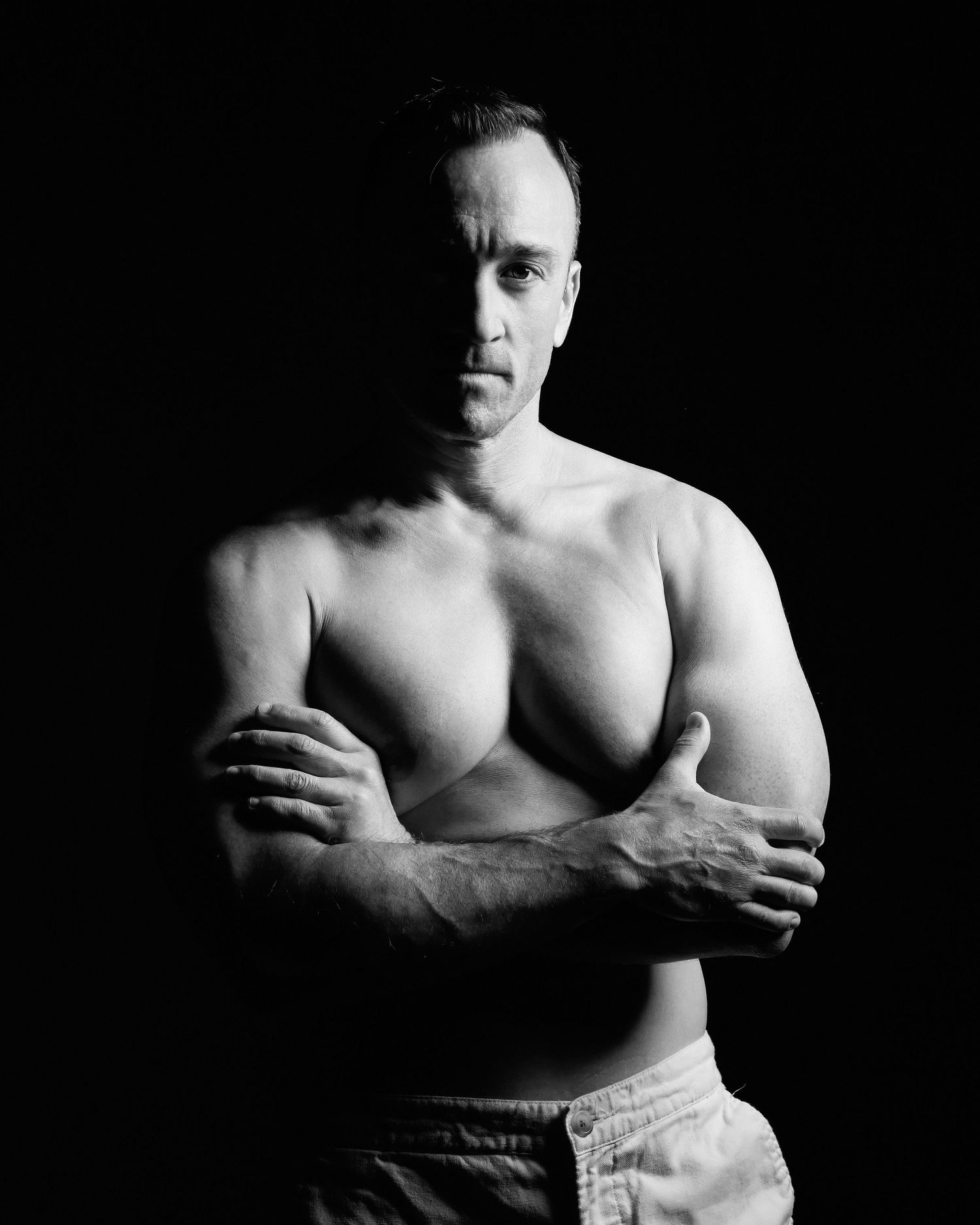 David G Holt Photography - Black and white portrait of shirtless muscular man with crossed arms.