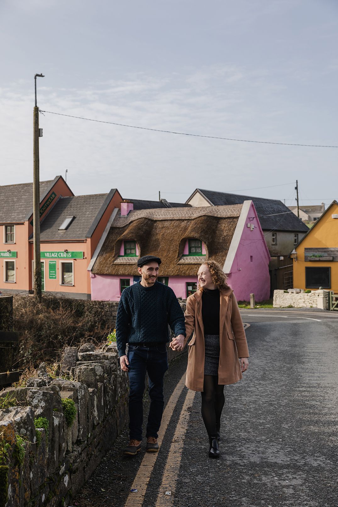 Couple walking holding hands on the colorful streets of Doolin