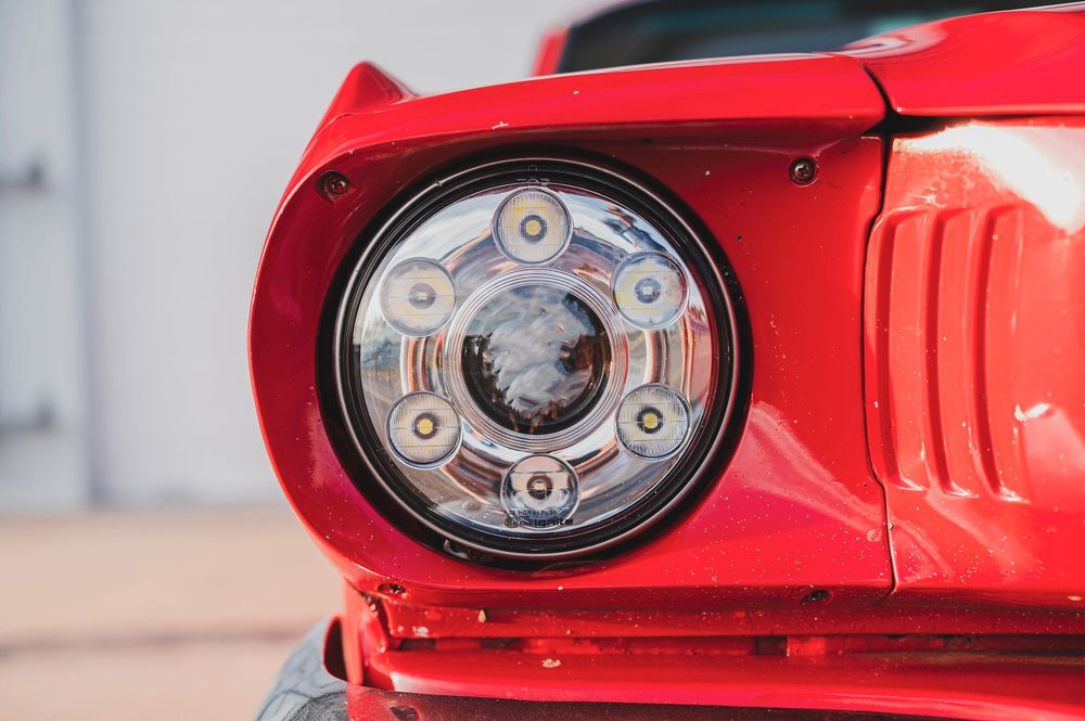 Close-up view of red vintage Mustang fuel cap and gas door details.