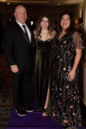 Formal event photos showing black suits and elegant dresses against a purple carpet backdrop.