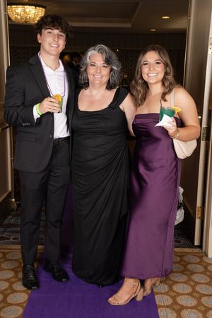 Group of formally dressed guests celebrating with drinks at an elegant evening event.