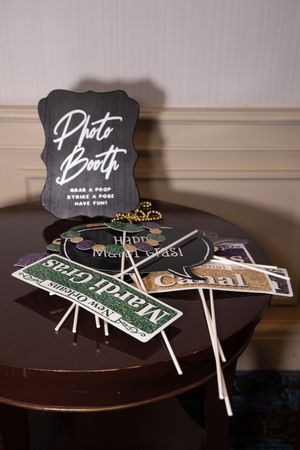 Photo booth props and signs displayed on a dark wooden table surface.