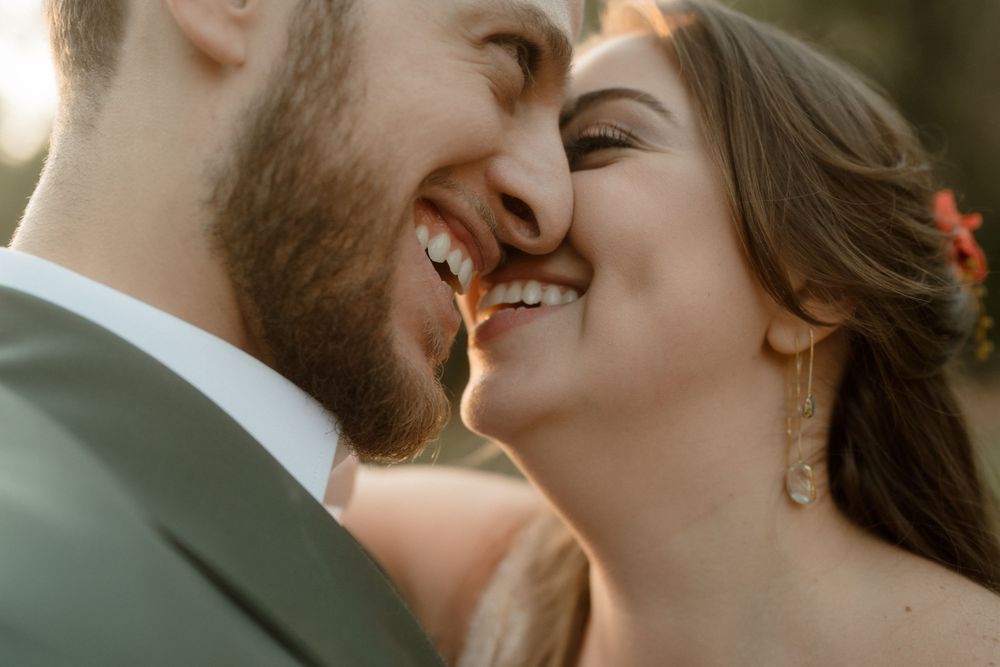 Romantic couple shares an intimate moment during their wedding photoshoot in warm natural lighting.