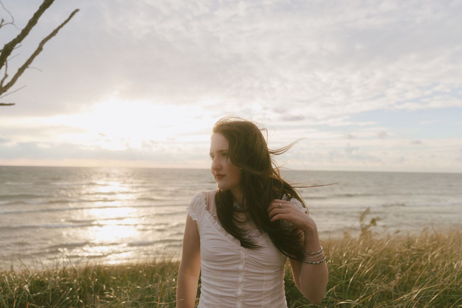 A senior portrait during sunset at a beach in Muskegon, Michigan by Richelle Healy Photo.