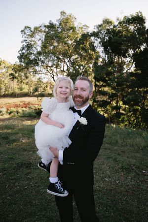 A formal wedding portrait taken outdoors with eucalyptus trees in the background.