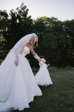 A flowing white wedding dress twirls gracefully in a series of outdoor dance movements.
