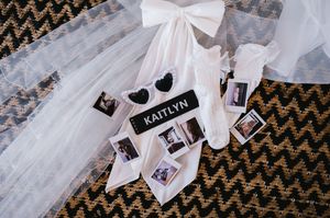 A collection of polaroid photos and white ribbons arranged on a dark chevron patterned background.