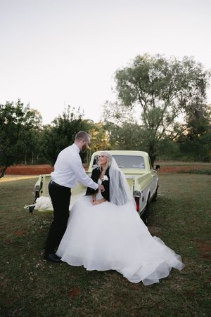 A romantic wedding photoshoot in a field showing playful poses with a flowing white dress.