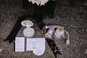 Wedding place cards and decorative details arranged on a dark surface.