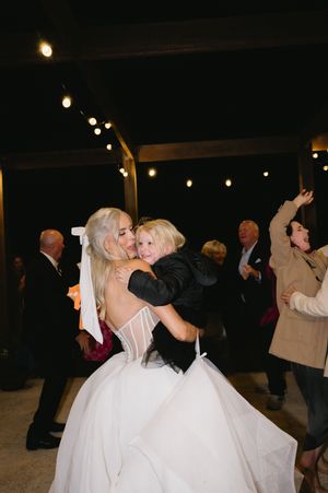 Wedding reception dancers enjoying a lively moment under string lights.