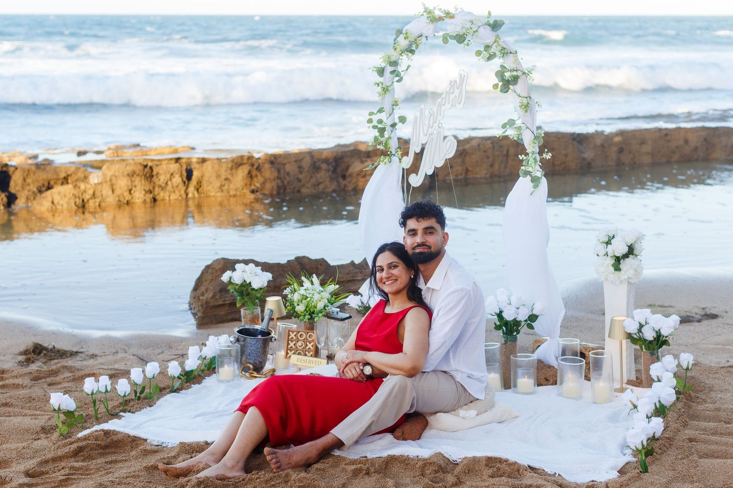Couples portrait. Proposal and engagement session. Man and woman seated on the beach. Kikita Surf Beach, Dorado, Puerto Rico.