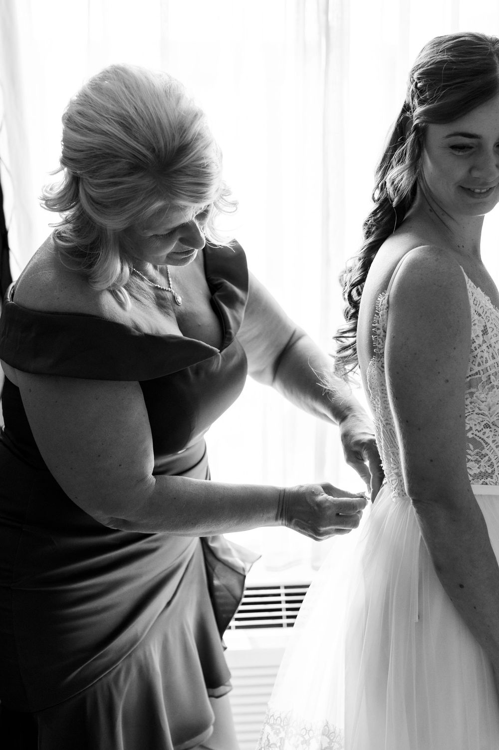 Black and white series showing the intimate moments of wedding dress preparation.