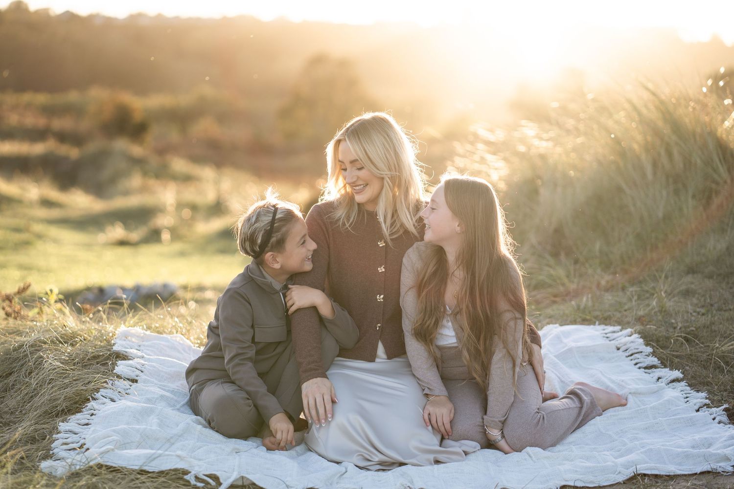 Family enjoying a sunset moment together on a sandy beach.