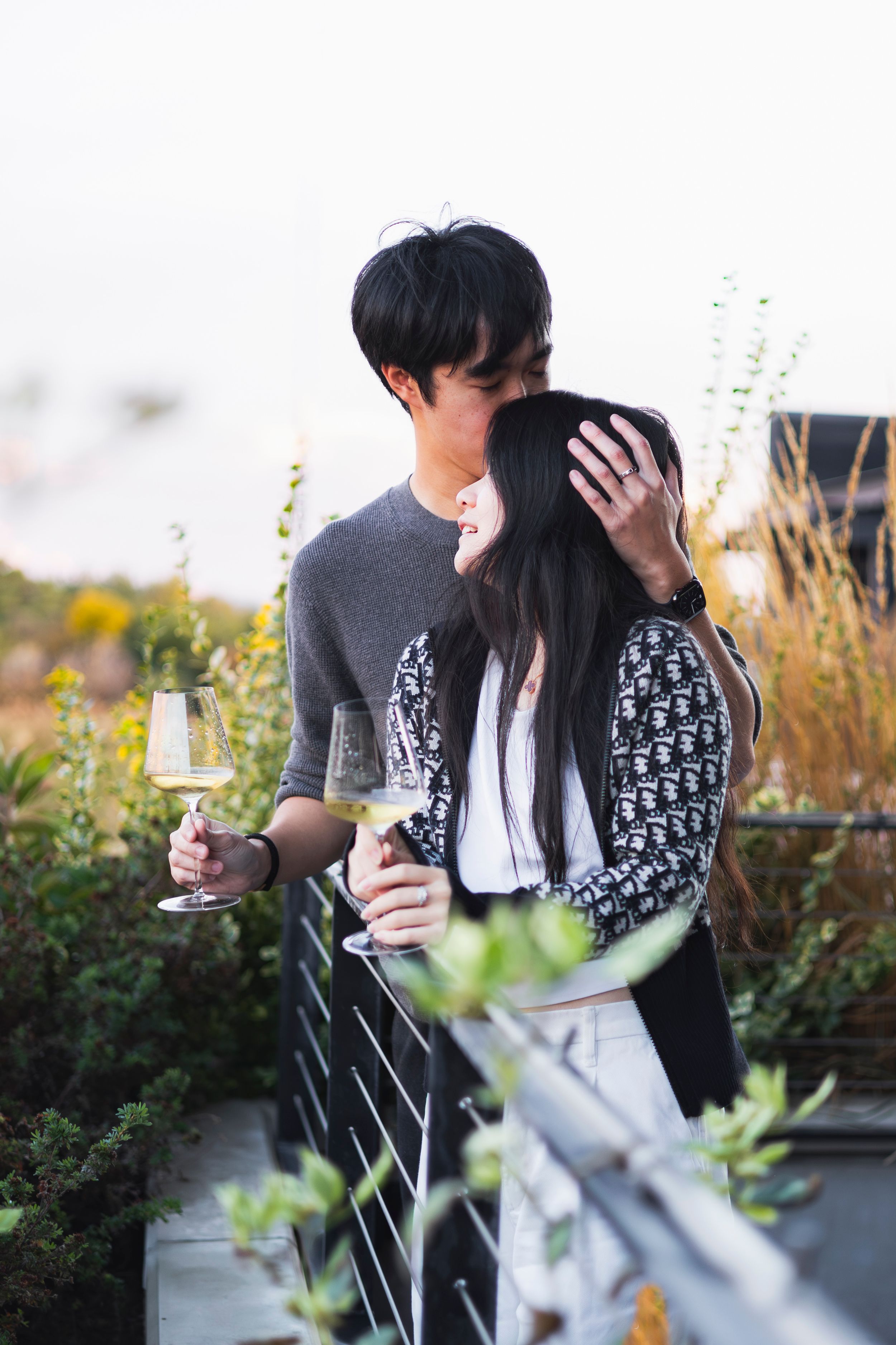A man kisses the top of his fiances head affectionately