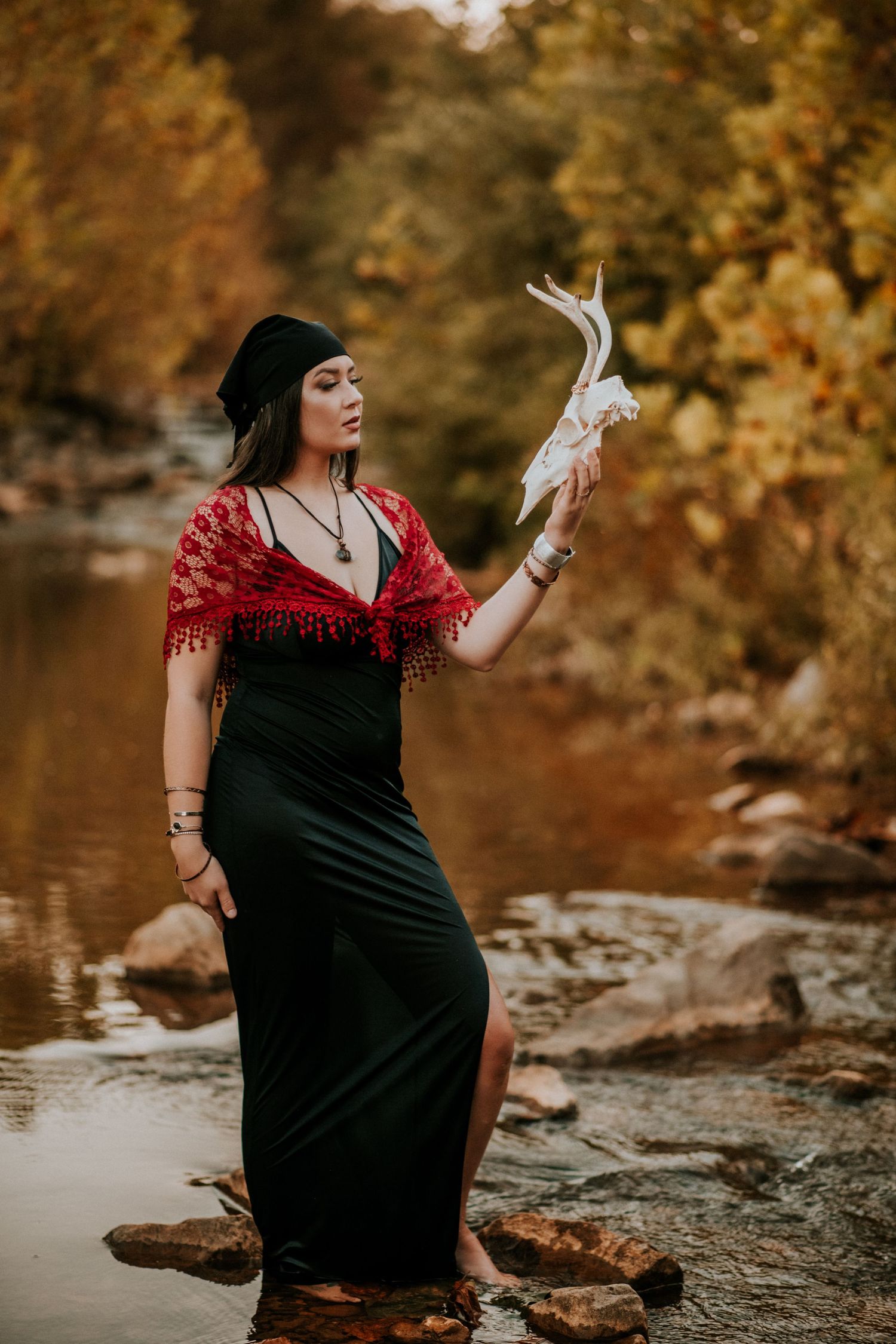 A woman standing in the river holding an animal skull at Fort Campbell, Tennessee.