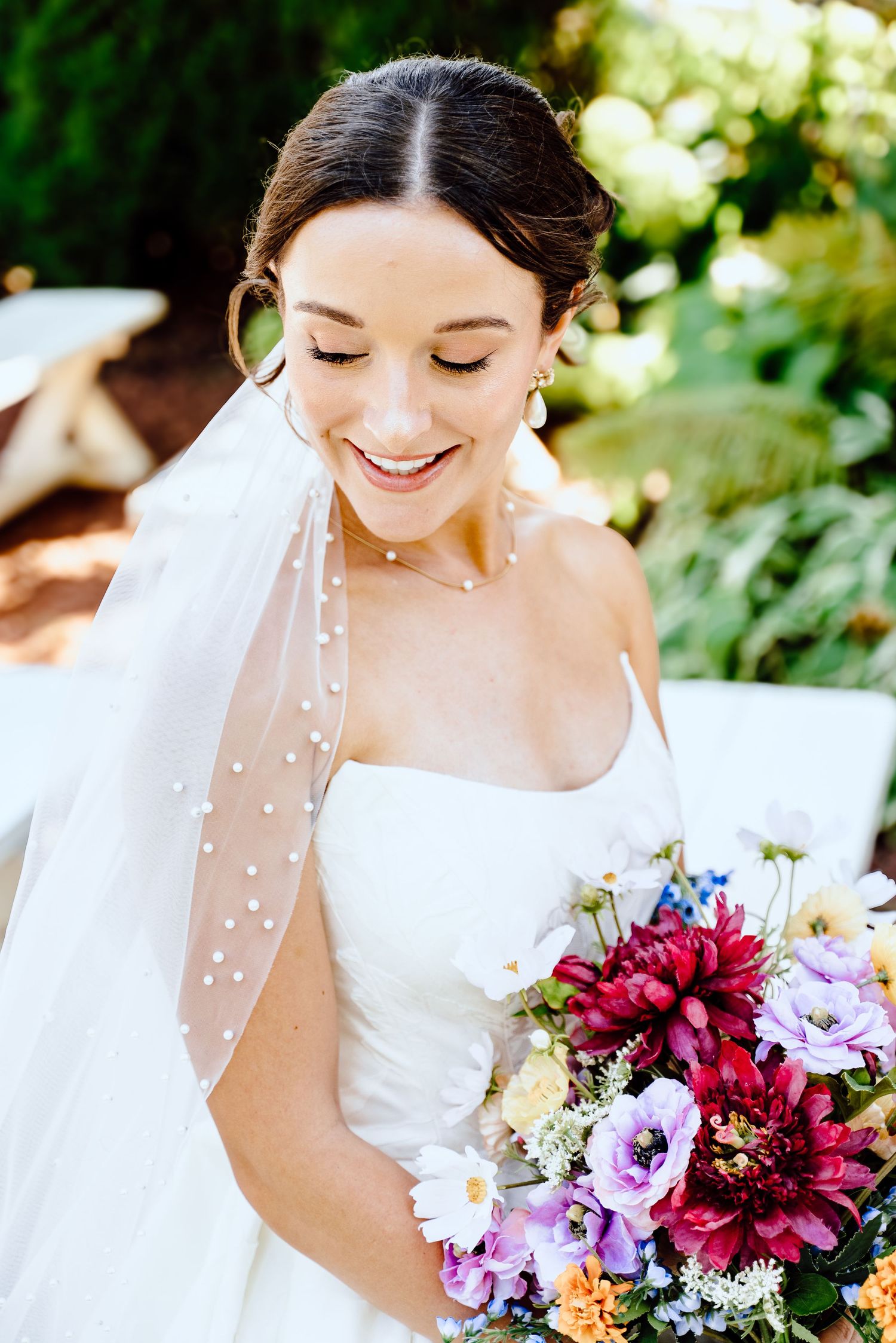 A bridal portrait series showing a white wedding dress and vibrant burgundy and purple floral bouquet in natural light.