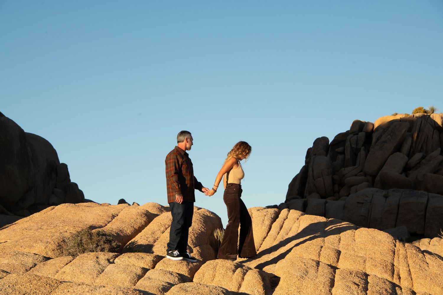 Couple holding hands in Joshua Tree National Park. Photo by Joshua Tree Photographer, Elena Ray