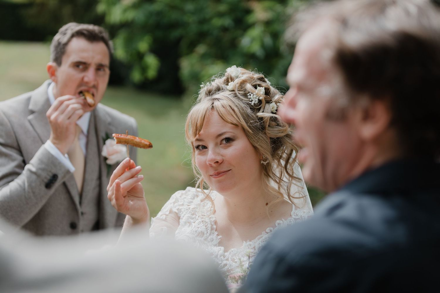 A wedding couple shares a joyful moment during their outdoor celebration in a garden setting.