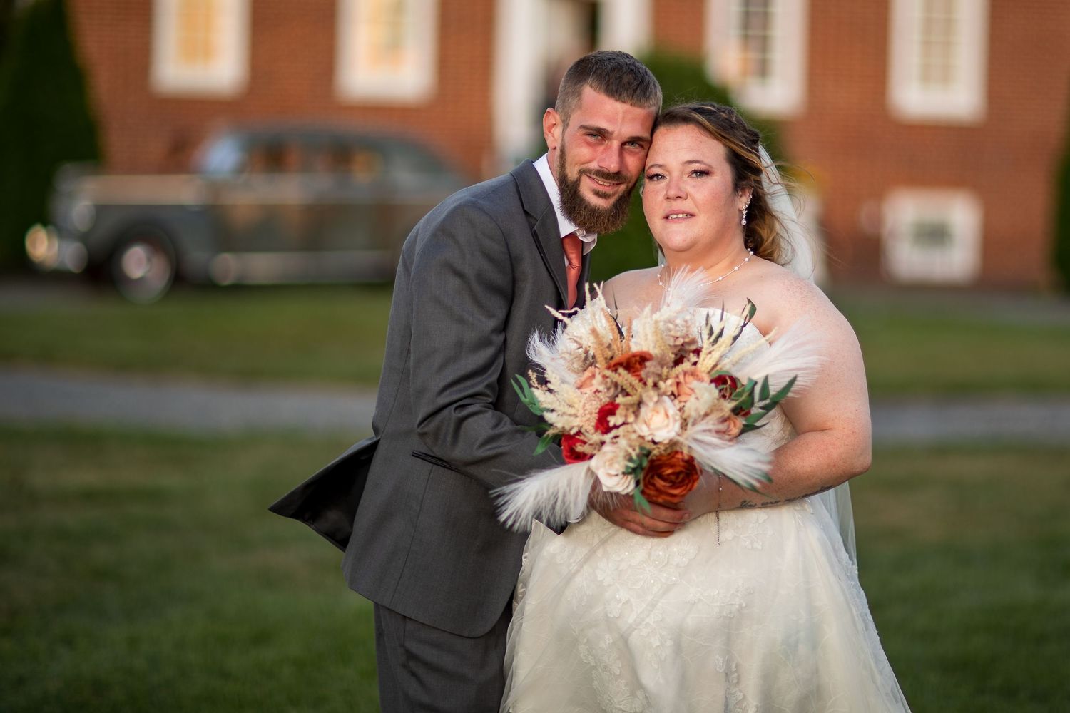 frederick maryland wedding photographer Wedding couple shares joyful moments on the grounds of a brick building.