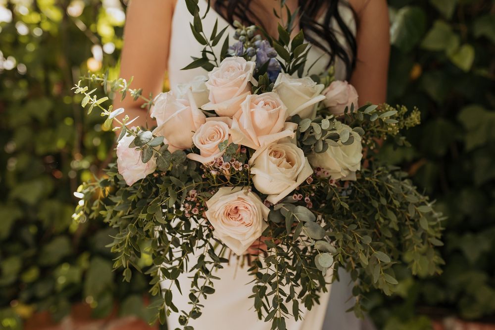 Elegant bridal bouquet featuring blush roses and mixed greenery against a natural outdoor background Inn of the Seventh Ray in Topanga.