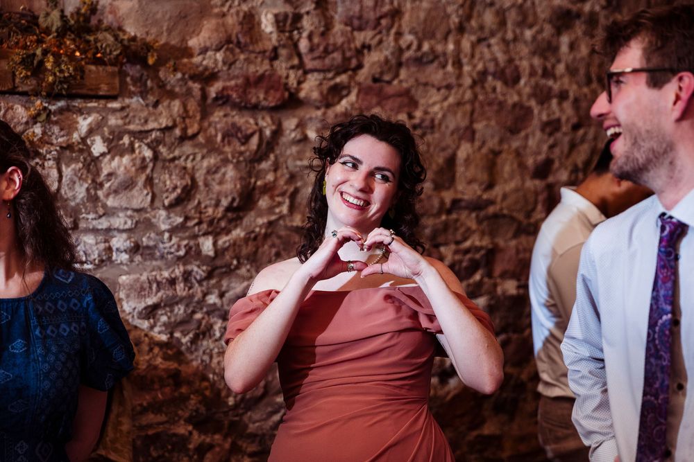 A sequence of candid moments captured at a wedding reception with brick walls in the background.