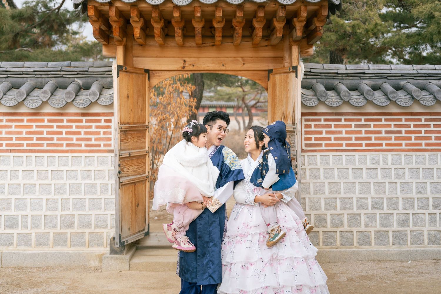 A couple shares a romantic kiss in front of traditional Korean architecture with ornate wooden details and stone walls.