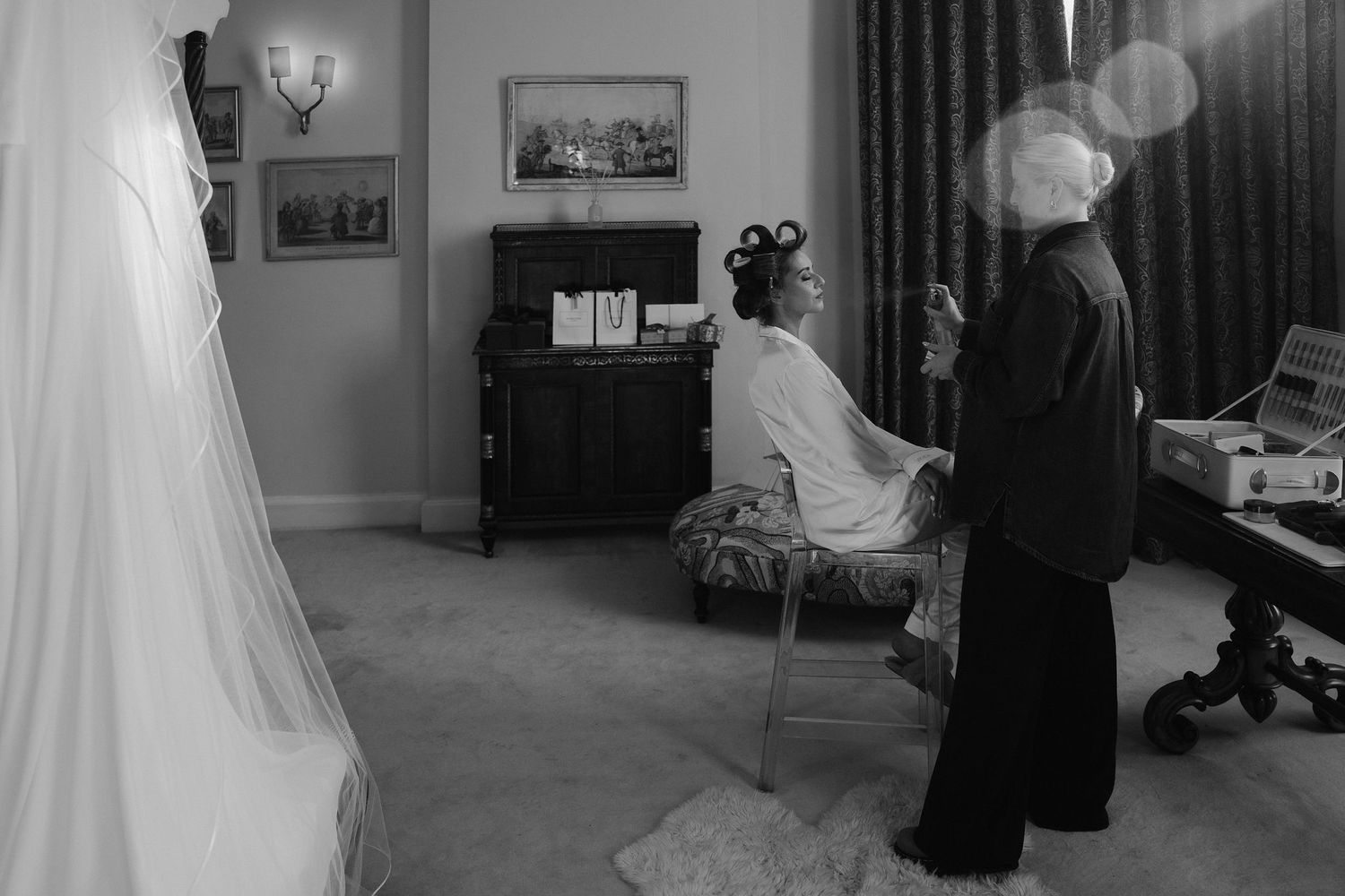 make up artist spraying setting spray onto the brides finished make up at Iscoyd park
