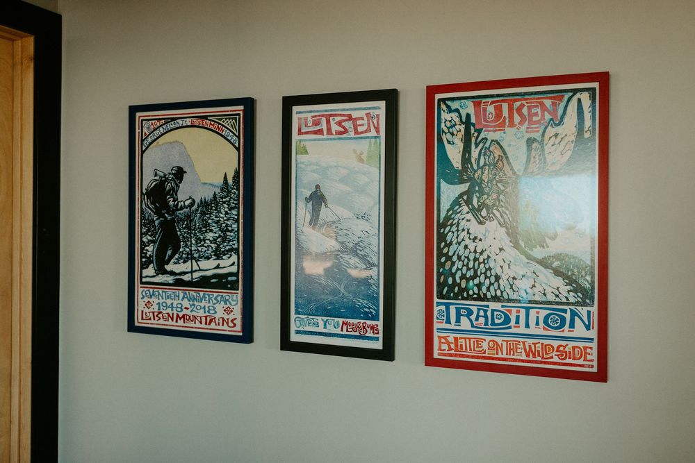 Row of framed vintage concert posters hanging on a beige wall in an indoor venue.