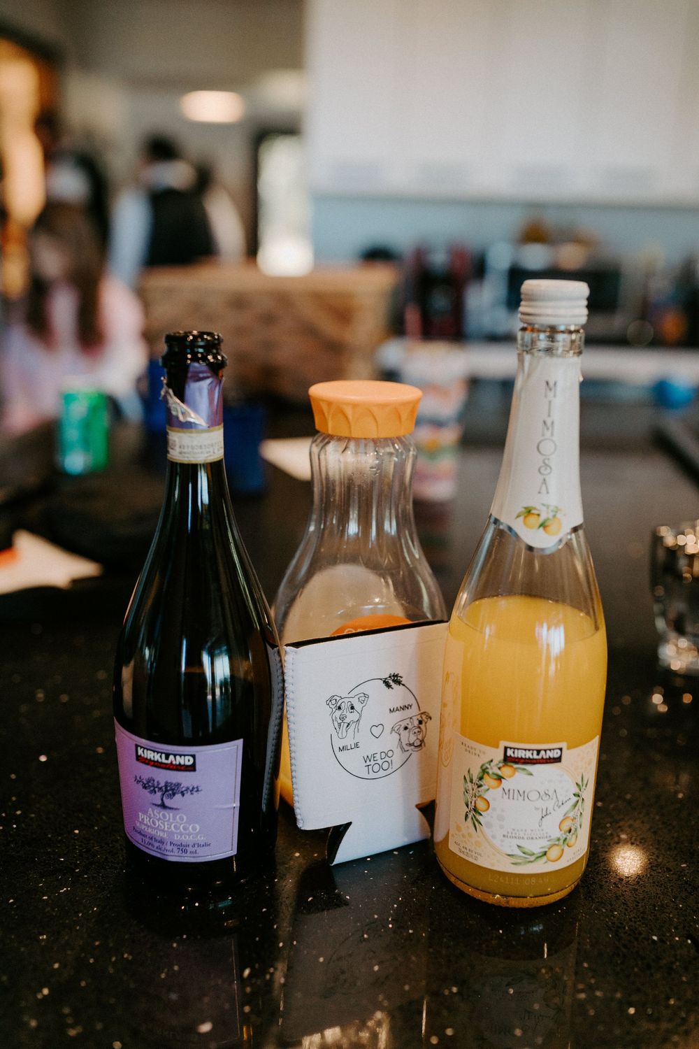 Artisanal bottled beverages including craft sodas and juices arranged on a dark counter surface.