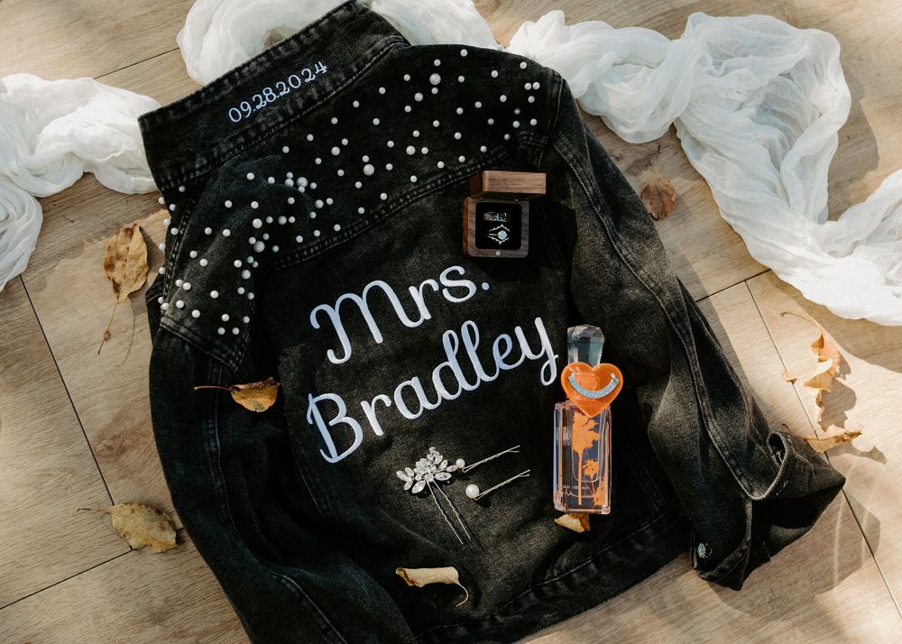 Black face masks with white polka dots and rhinestone text decorations laid out on a wooden surface.