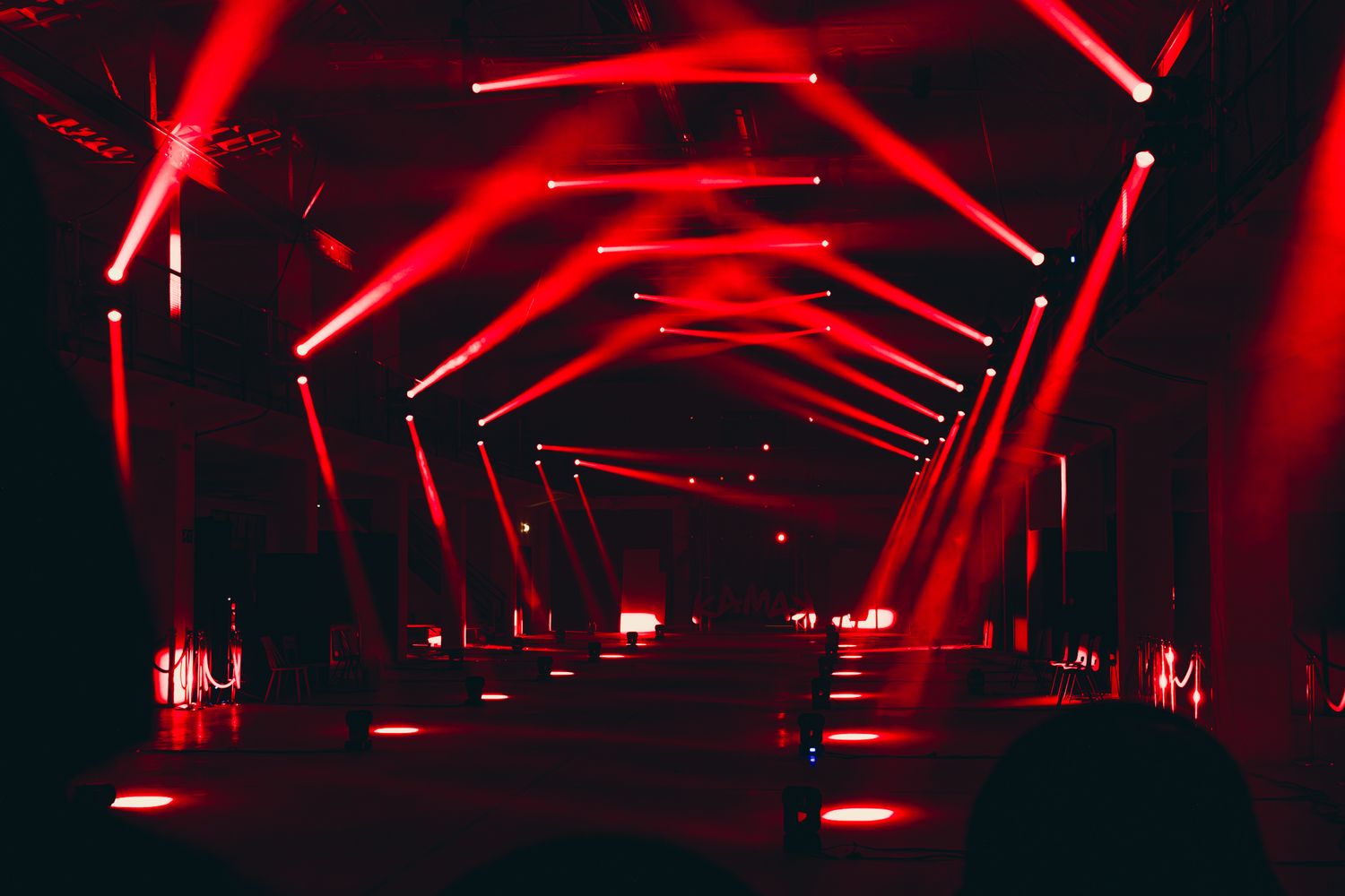 Lichtspel in een donkere hal waarbij de rode lichtbundels een geometrisch patroon tonen