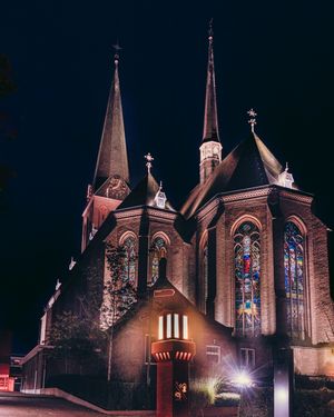 De Lambertusbasiliek in Hengelo (OV) verlicht in de avond en aan de achterzijde van het gebouw gefotografeerd vanuit een laag standpunt.