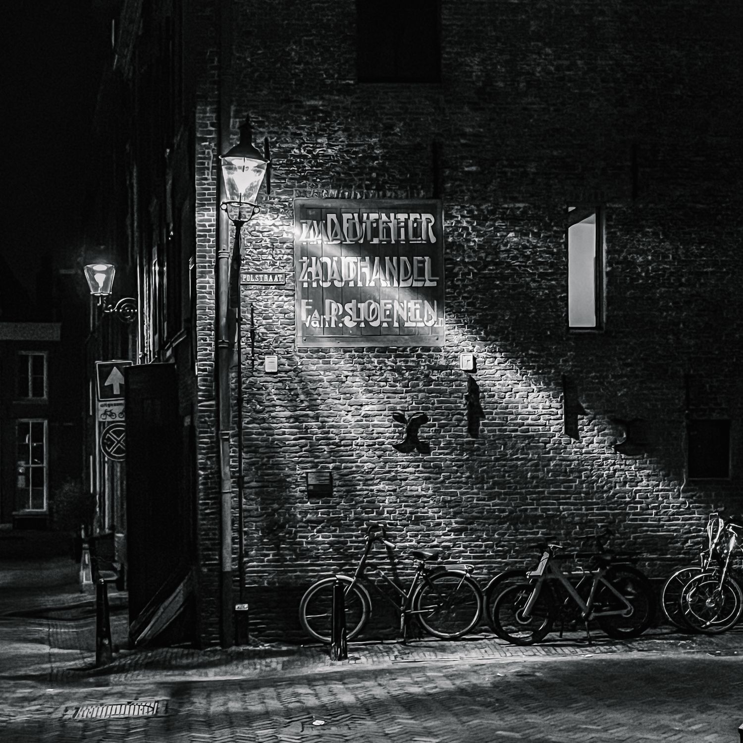 Deventerstraatje verlicht in de avond in zwartwit