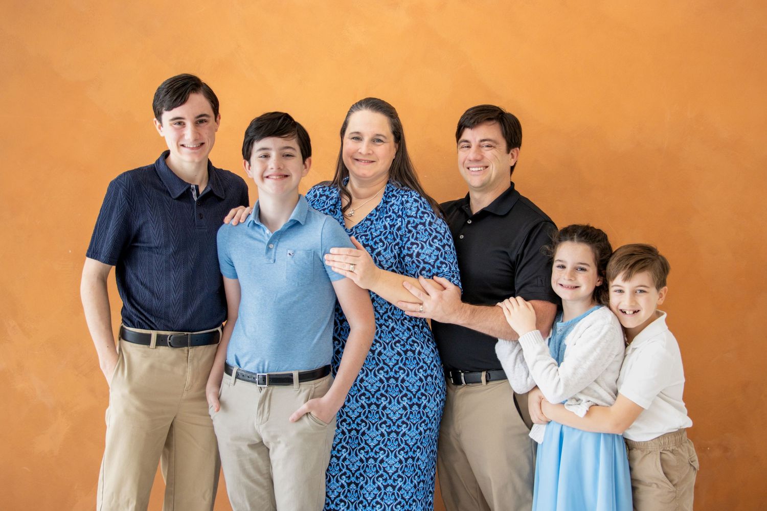 Large family studio portrait session featuring coordinated outfits, timeless posed group photography, and clean studio lighting